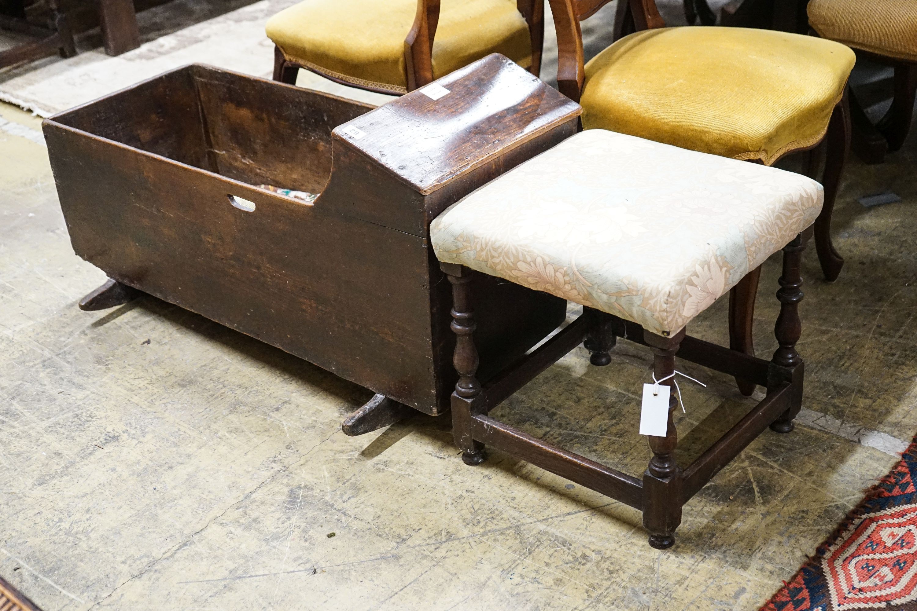 An 18th century elm cradle, length 97cm, depth 95cm, height 54cm together with a turned oak stool with padded seat, width 43cm